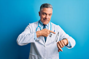 Doctor pointing at his watch because you have more time now if you are a qualified Floridian.